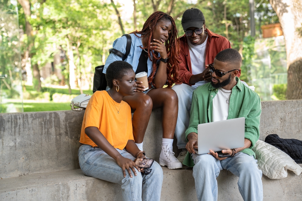 Company,Of,Relaxed,Thoughtful,Students,Study,Outside,Using,Laptop.,Interested